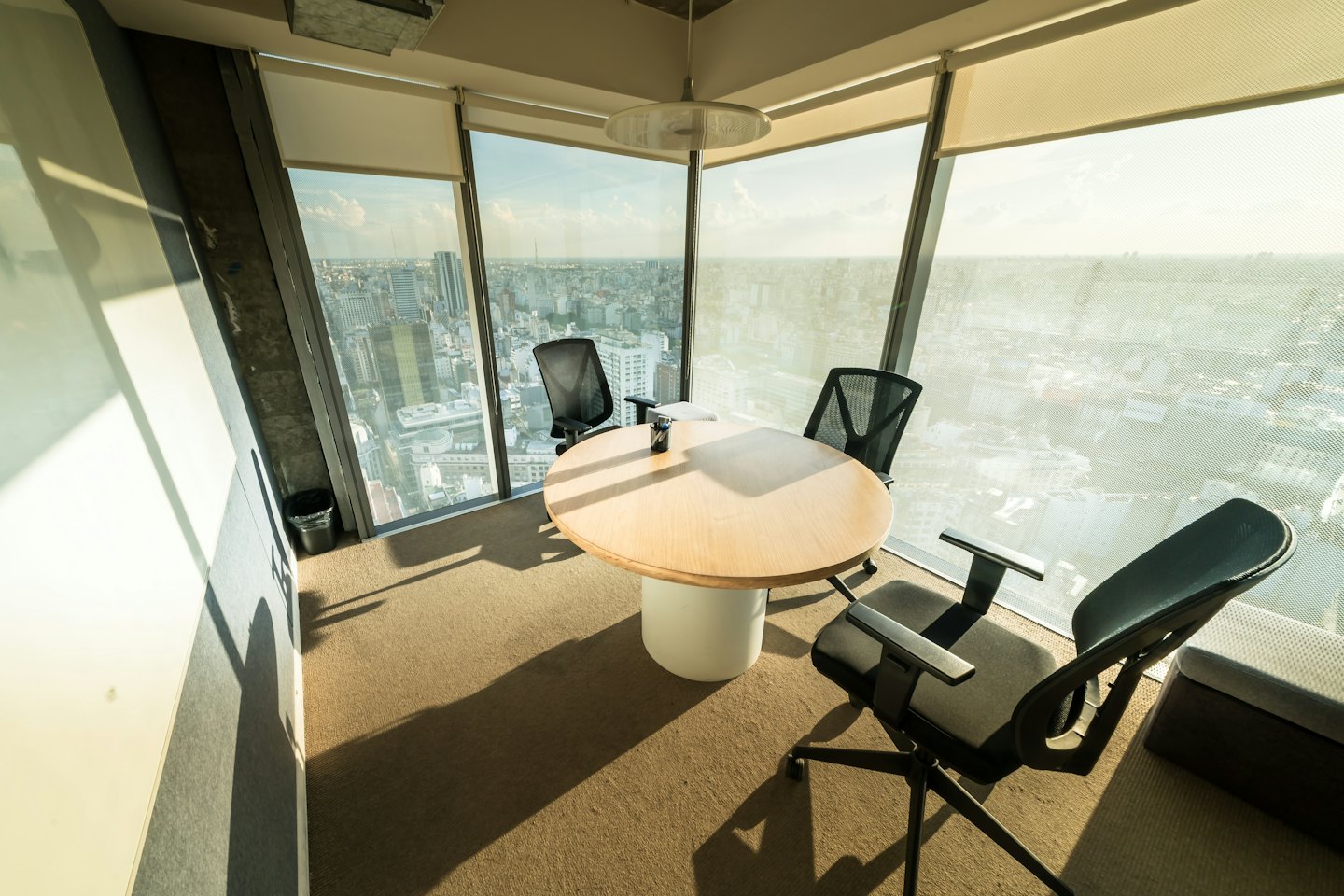 Modern conference room with wood table and city view.